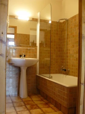 salle de bain avec porte permettant la douche, un sèche serviettes, un Wc