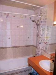 salle de bains carrelée avec bain et douche